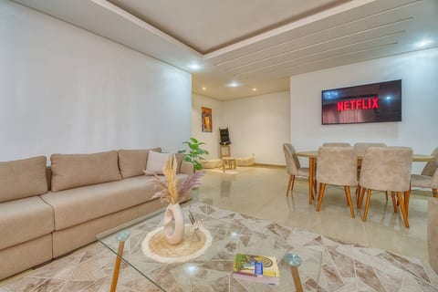 Un salon lumineux et spacieux, décoré avec goût, équipé d’un grand canapé confortable, d’une télévision connectée