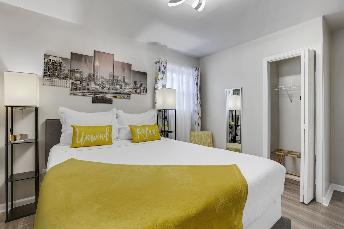 Our canary yellow queen bedroom includes two night lamps, hangers, extra plugs and usb ports, and a luggage holder. The bathroom is just one step outside the room.