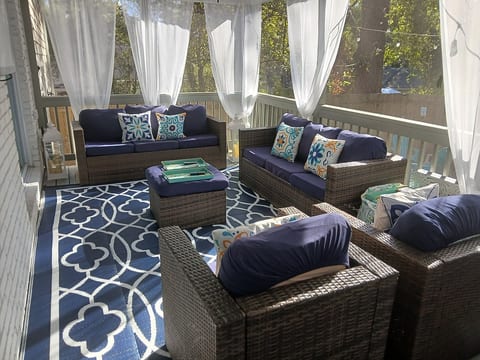 Relax on the screened-in backyard Deck, with comfortable seating and a peaceful view.