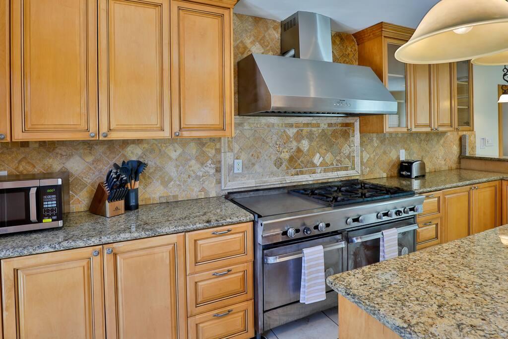 An upscale and fully-equipped kitchen with state-of-the-art appliances, meticulously crafted to enhance your culinary experience and create outstanding meals.