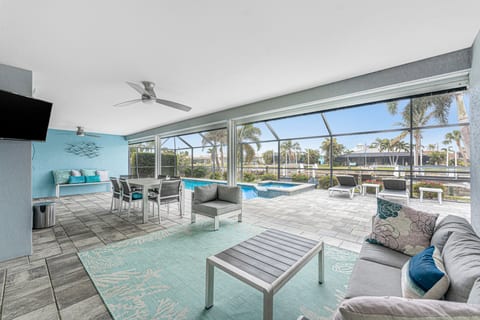 Furnished outdoor lanai with TV, pool, hot tub, grill