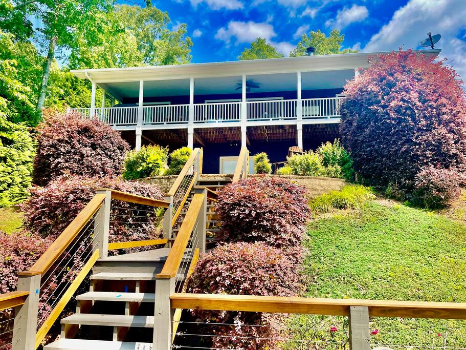 Newly renovated exterior (May 2022) has gorgeous deck and stairs leading from cottage to water 