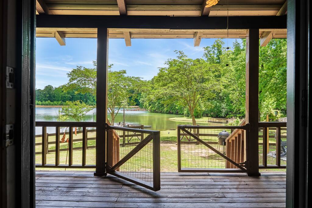 Backyard Bliss!  The stunning private lake sits directly in the back of the property fenced yard.  A charcoal komodo style grill, fire pit, hot tub, swing bed and more all just steps from the lodge