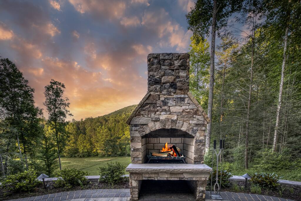 This custom hand built stone fireplace is a work of art! The curved patio has  Adirondack chairs for wrapping around so everyone stays warm and cozy 