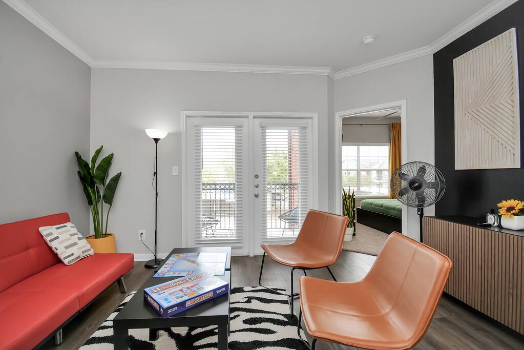 This inviting living space boasts a modern and stylish design, perfect for relaxation and entertainment. The comfortable red sofa and plush brown armchairs create a cozy atmosphere.


