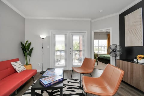 This inviting living space boasts a modern and stylish design, perfect for relaxation and entertainment. The comfortable red sofa and plush brown armchairs create a cozy atmosphere.


