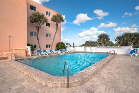 Enjoy the community pool with lounge chairs, palm trees, and a sunny pool deck