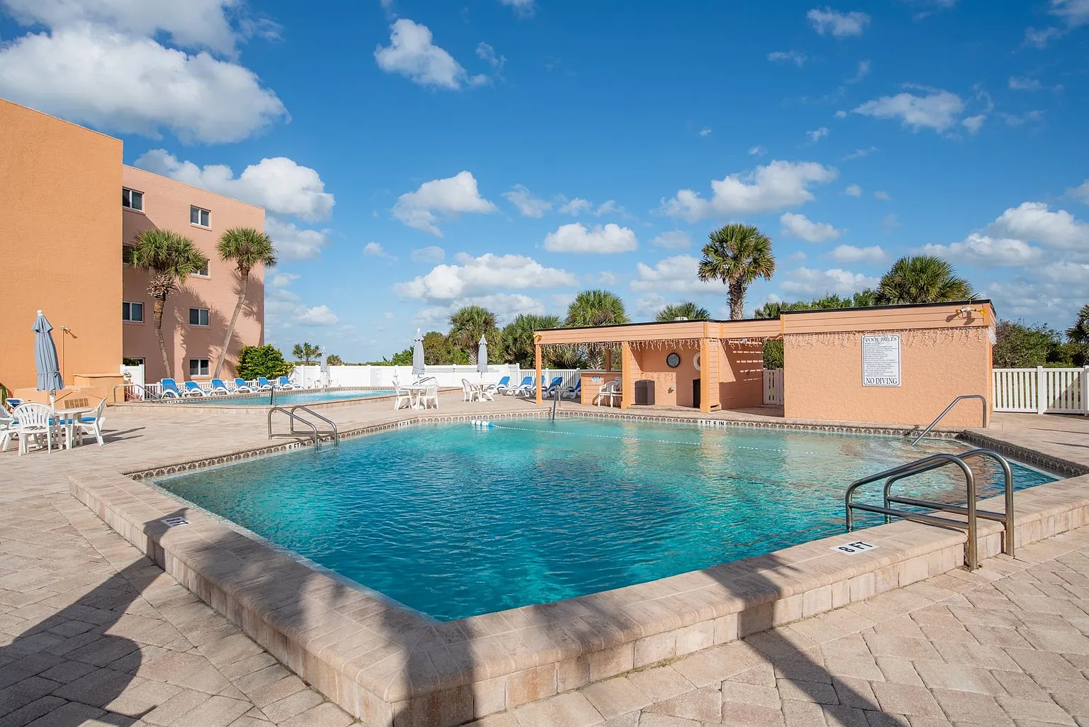 Enjoy the community pool with lounge chairs, palm trees, and a sunny pool deck just steps from St. Augustine Beach