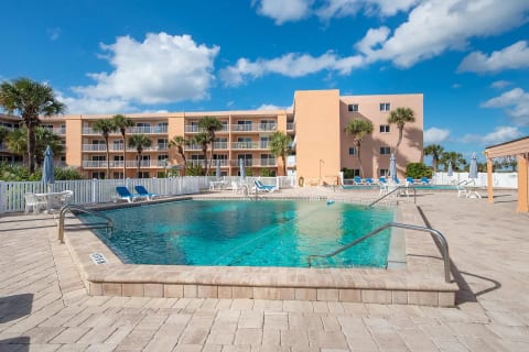 Second community pool with lounge chairs, palm trees, and plenty of space to relax under the Florida sun.