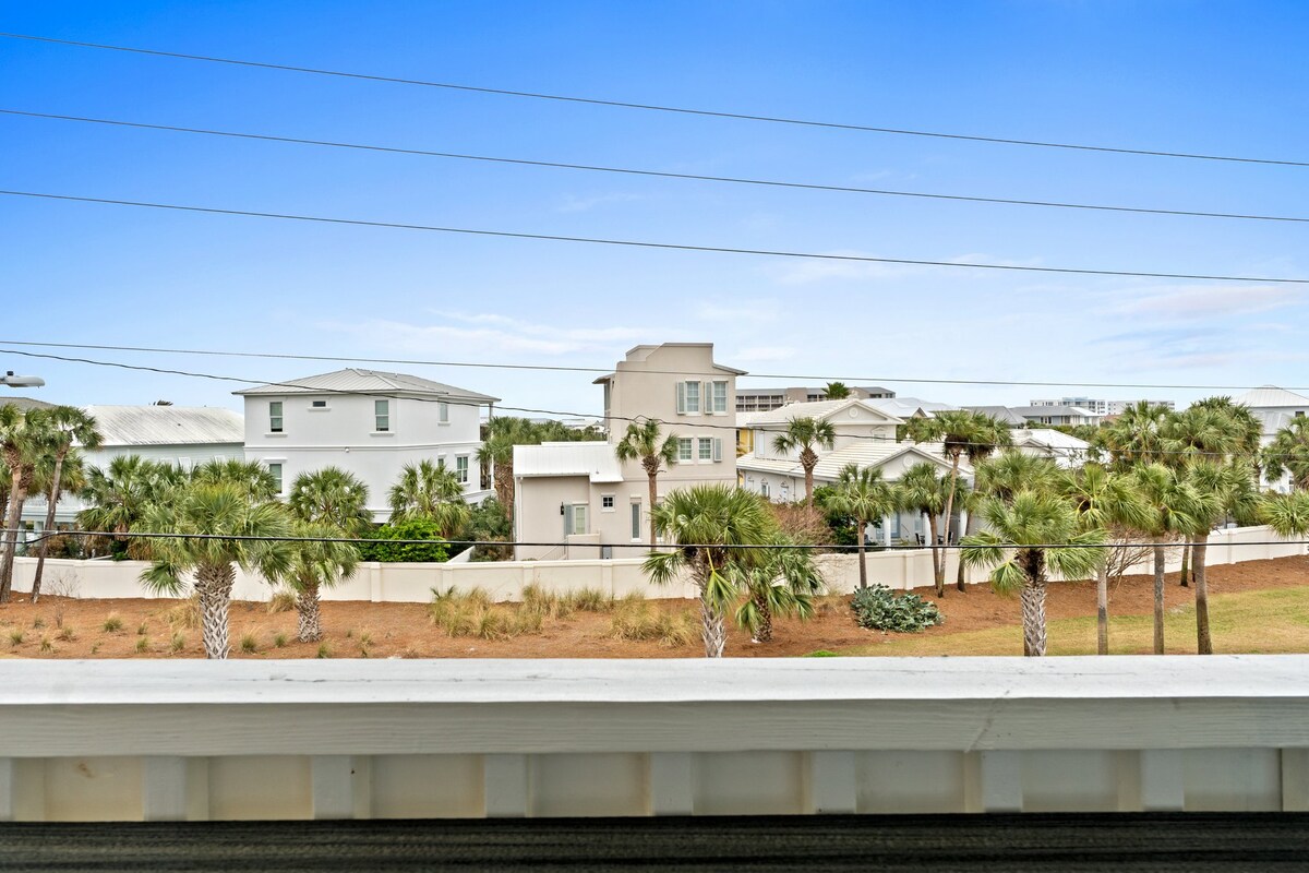 Scenic balcony view of classic beachside homes and swaying palms.
