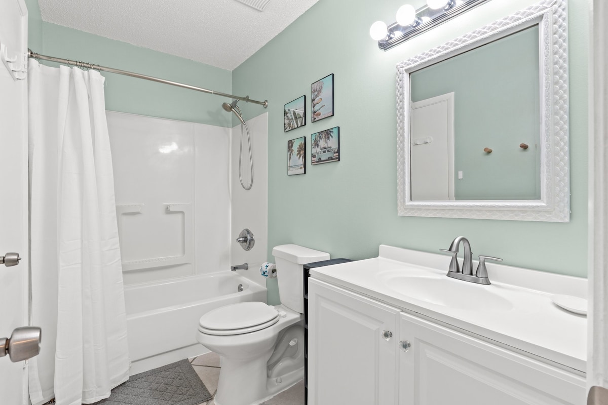 Fresh and inviting full bathroom with shower/tub combo and modern touches.