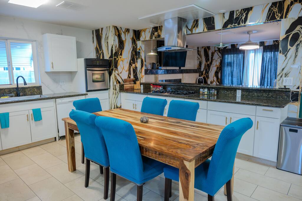 Stunning modern kitchen, where high-fashion design meets everyday functionality. The striking black-and-gold marble-look backsplash sleek stainless steel appliances and ample counter space create an inspiring environment for cooking and entertaining.