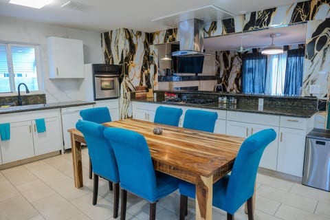 Stunning modern kitchen, where high-fashion design meets everyday functionality. The striking black-and-gold marble-look backsplash sleek stainless steel appliances and ample counter space create an inspiring environment for cooking and entertaining.