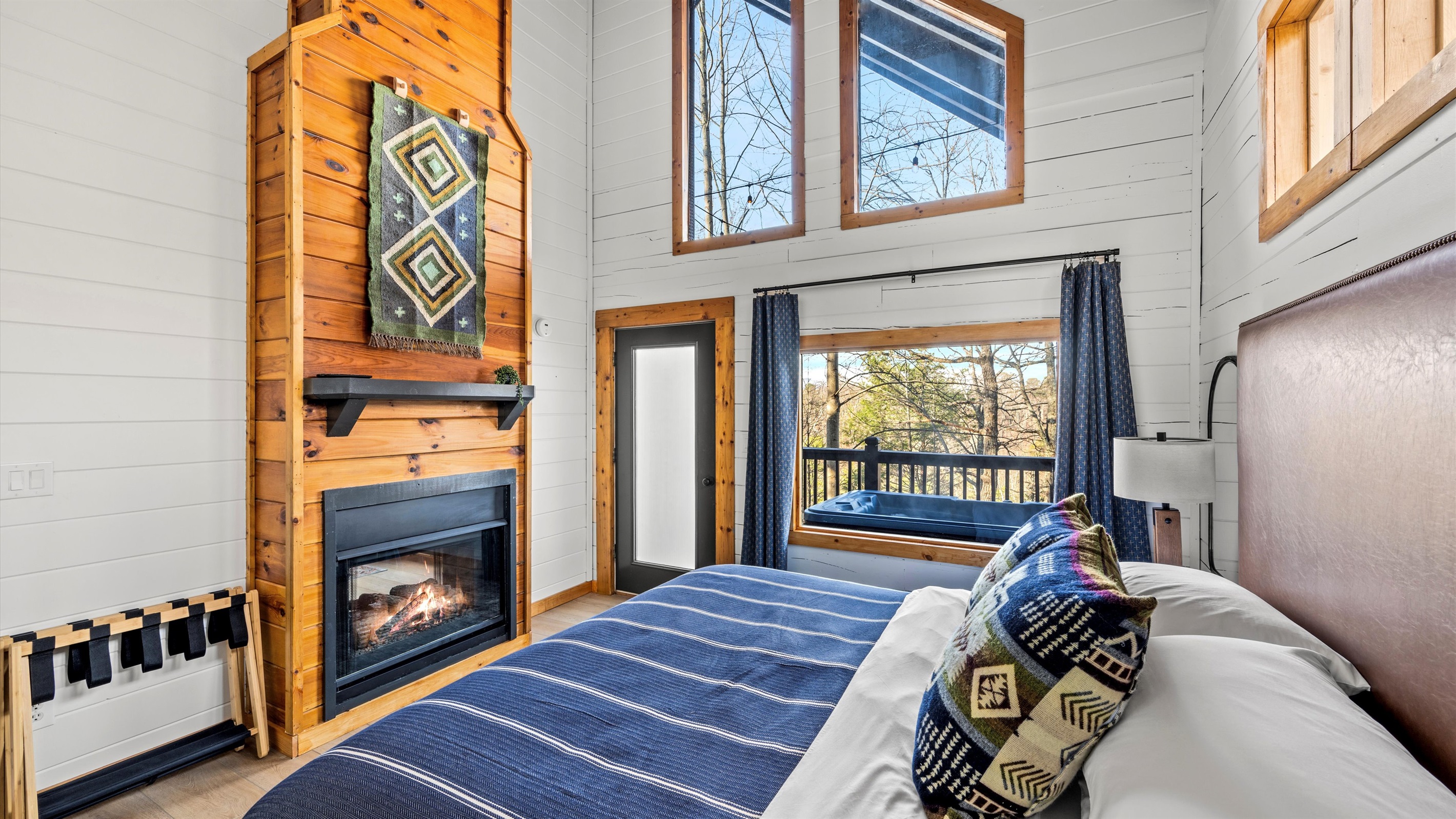 Bedroom retreat: offers a luxurious king-size bed, a warm gas fireplace, and expansive windows that flood the space with natural light. Step outside to your private hot tub with forest views, or unwind indoors surrounded by rustic-chic charm.