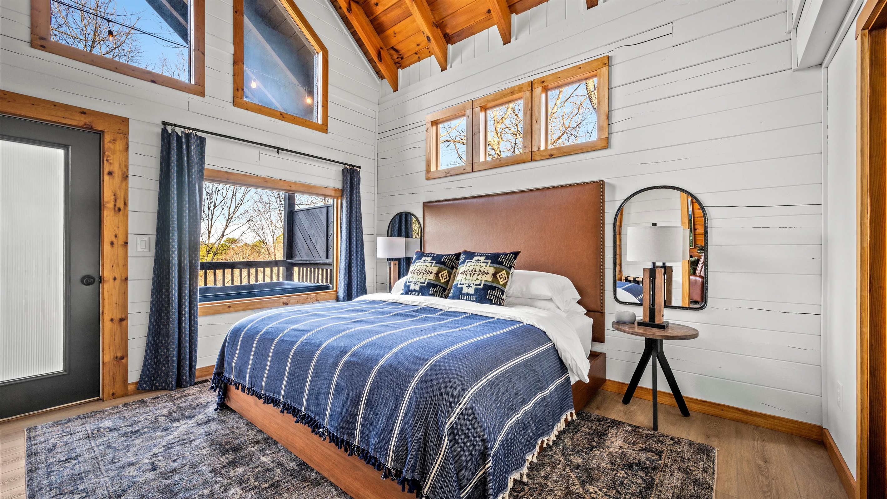 Wake up in this cozy, romantic cabin bedroom with vaulted ceilings, picture windows, and direct access to a private deck. Soak in natural light, breathtaking forest views, and rustic charm—an ideal escape for couples seeking peace in the Smoky Mountains.