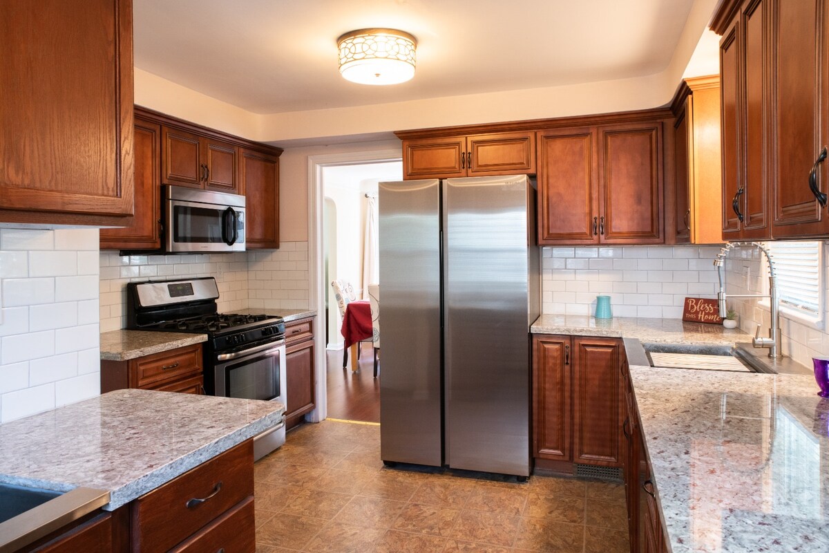 This kitchen has a classic and timeless feel with a touch of modern elegance. he kitchen boasts a suite of stainless steel appliances, including a refrigerator, oven, microwave, and gas stove.