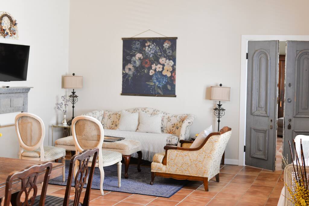 As you step inside, you’ll be greeted by a warm and inviting living room, featuring a plush sofa that beckons you to relax and unwind. Whether you’re curling up with a good book or enjoying a movie night on the flat-screen TV.