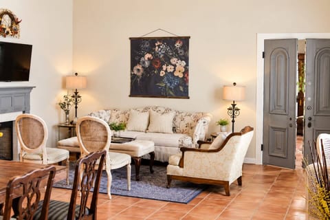 As you step inside, you’ll be greeted by a warm and inviting living room, featuring a plush sofa that beckons you to relax and unwind. Whether you’re curling up with a good book or enjoying a movie night on the flat-screen TV.