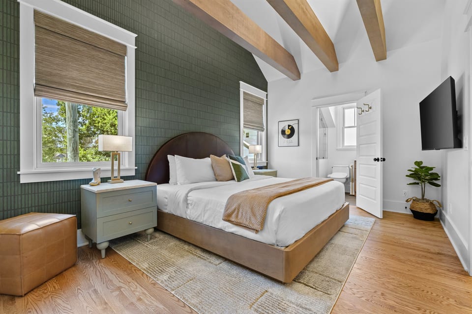 Bedroom retreat with vaulted ceilings, exposed beams, and a king bed.