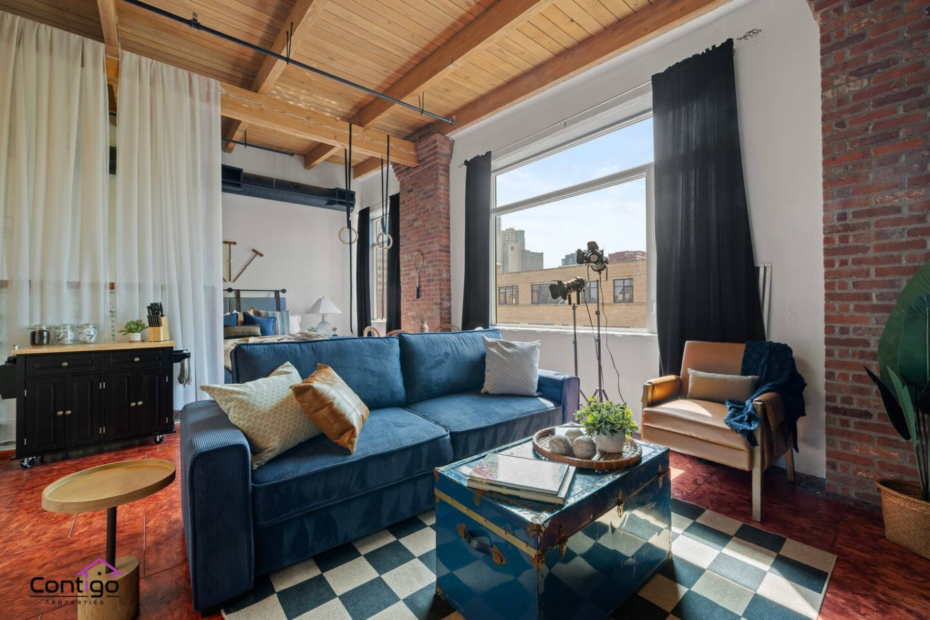 Cozy open-concept studio with stylish decor, exposed beams, and a sofa bed for extra guests.