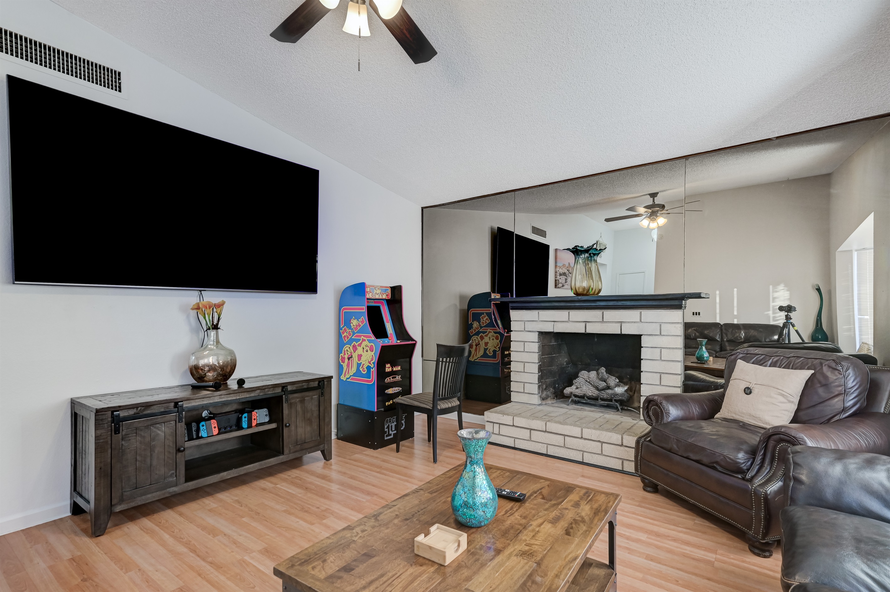 Living room 1 has leather couches, Mrs Pac-Man, an 86 inch tv, YouTube TV, a Nintendo switch with 4 controllers and a lot of games. It also includes karaoke with two wireless mics.
