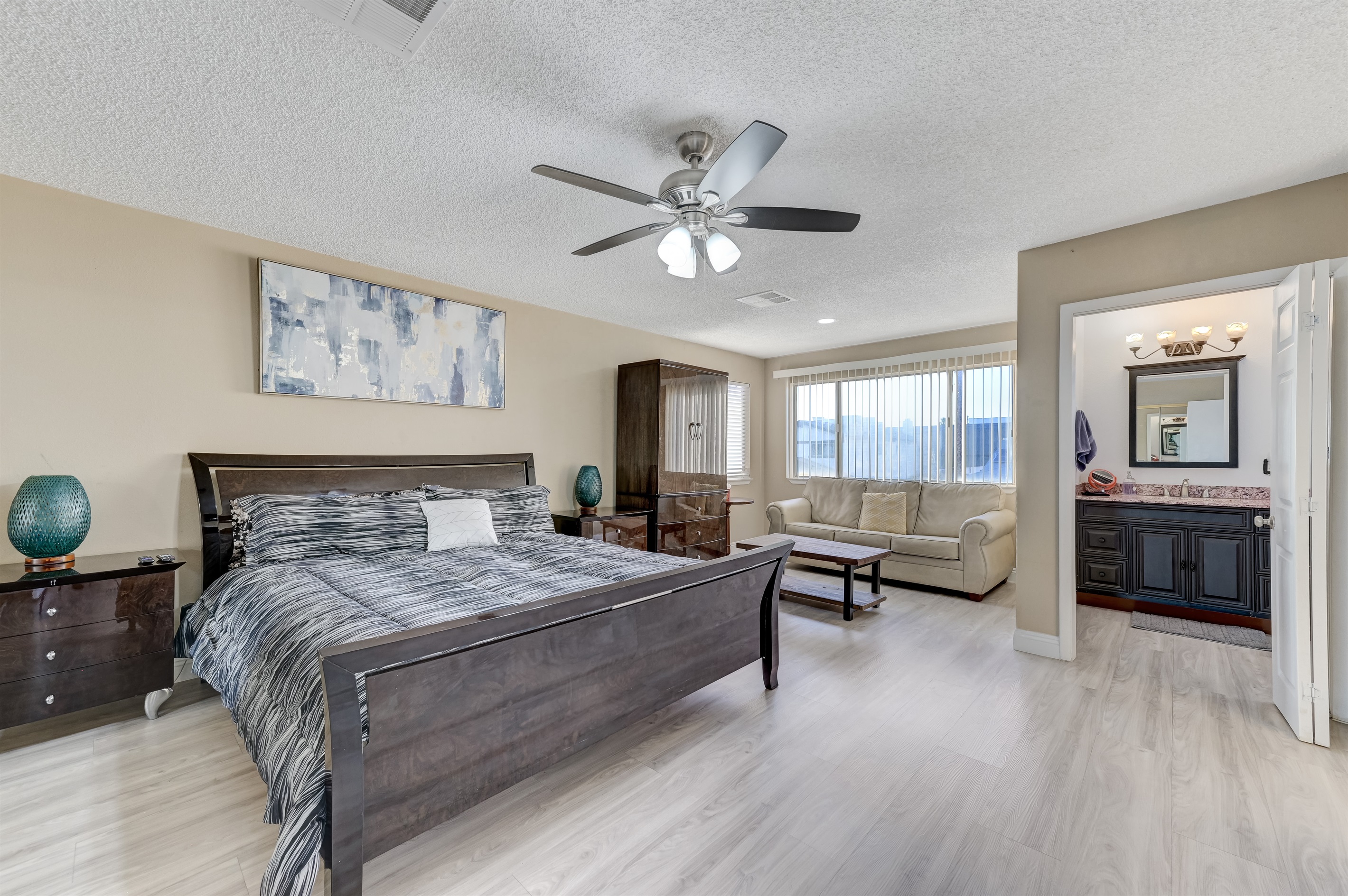 Master bedroom 2 has a California king bed, 60 inch smart tv, full bathroom 2, and a leather couch