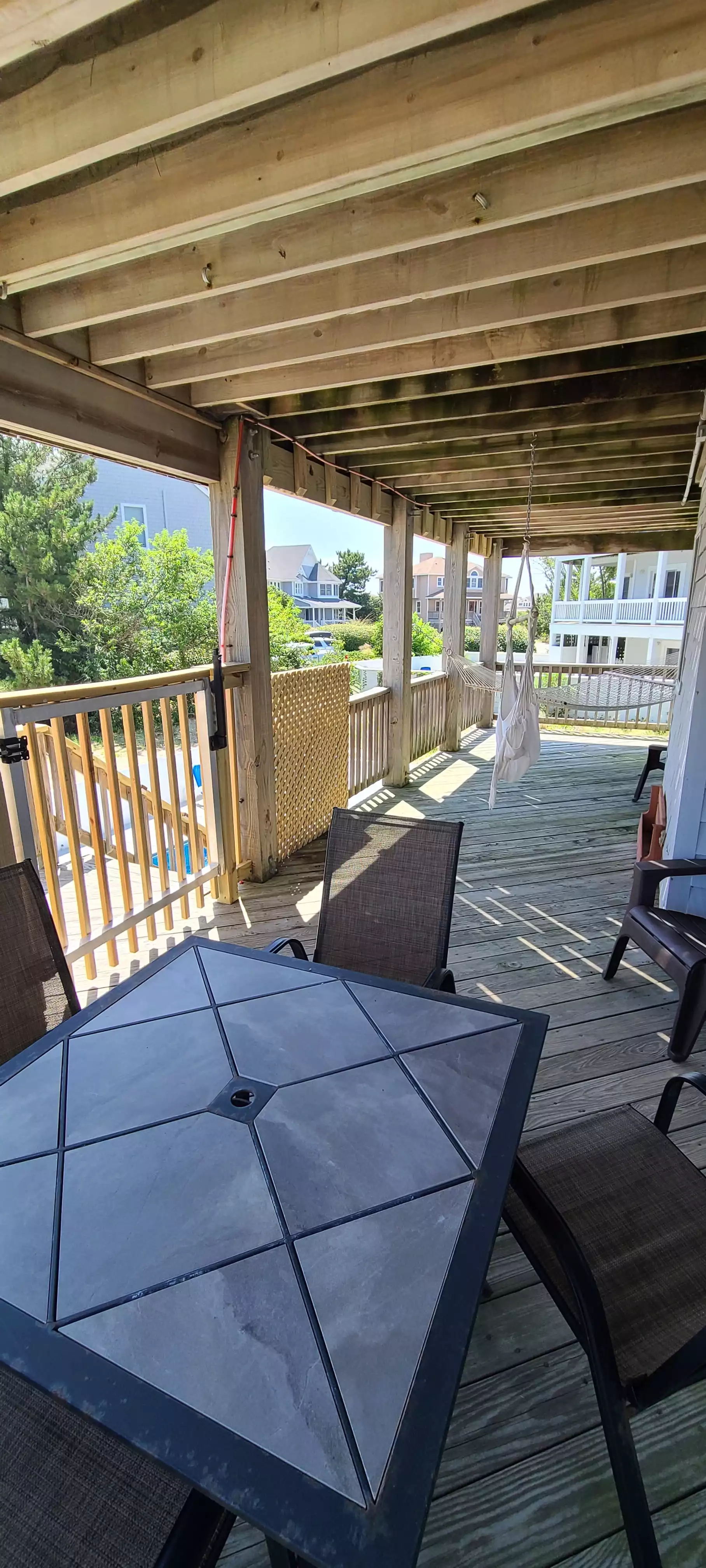 Rear lower deck with great relaxing space just above the pool with table, chairs, hammock and hammock chair. Rear lower deck with great relaxing space just above the pool with table, chairs, hammock and hammock chair. - Golden Dunes - Corolla, NC Private HEATED Pool - Corolla