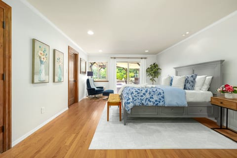 Bright, spacious master bedroom with cozy sitting area and garden views