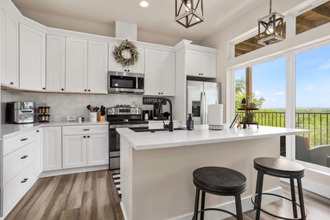 Entertain in this open-concept kitchen and dining space, featuring modern appliances and a large quartz island perfect for meal prep or casual dining. With direct access to the outdoor patio, this space blends comfort, style, and convenience.