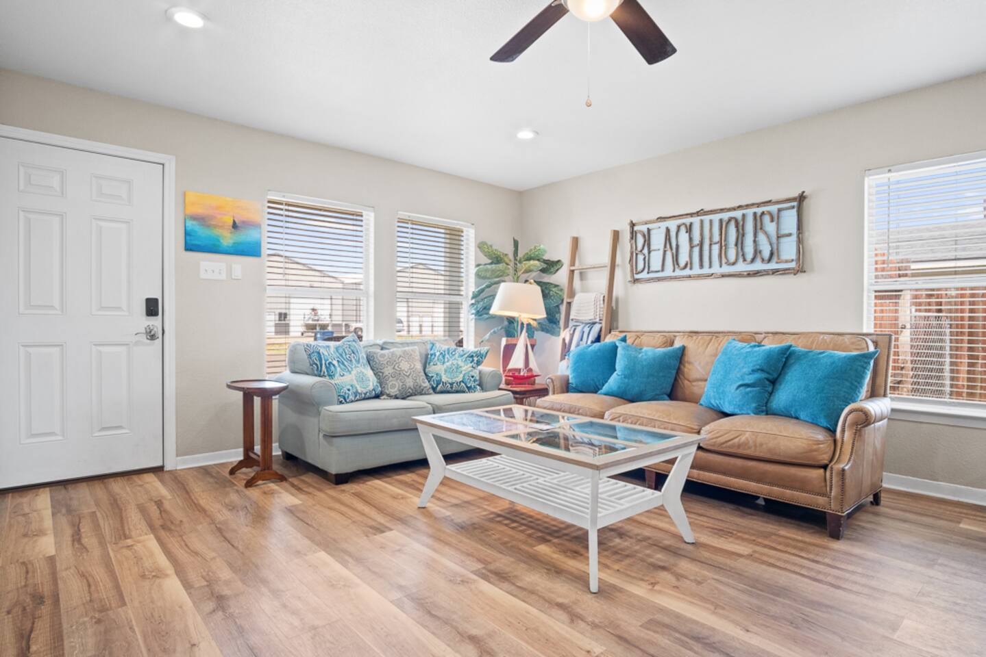Bright and breezy living space with cozy seating, coastal décor, and large windows letting in natural light. Perfect spot to relax after a day at the beach, unwind with a book, or enjoy family time with ocean vibes all around.