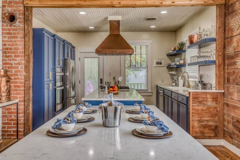 Large dining table seating eight comfortably, paired with hand-carved benches in a beautifully remodeled 1900s home. A welcoming space made for family meals, game nights, and unforgettable conversations.