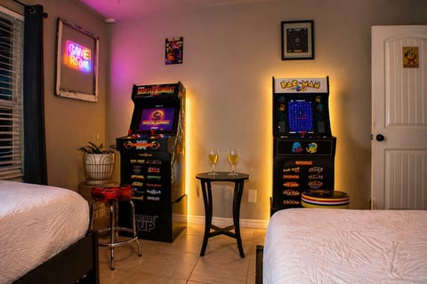 Game room with full-size Mortal Kombat and Pac-Man arcades — the competition starts the moment you walk in