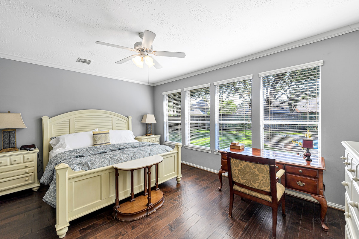 Relaxing primary suite with plenty of natural light and garden views.