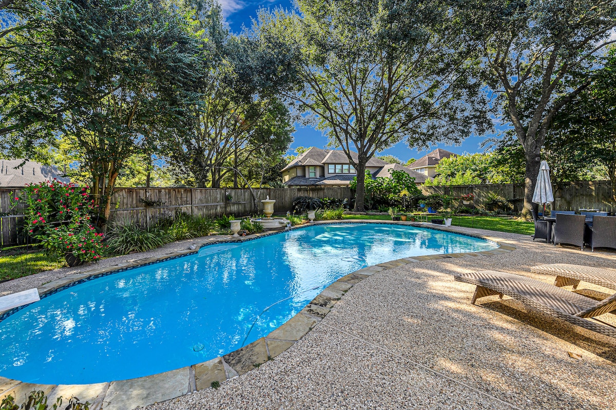 Sparkling pool surrounded by mature trees for shade and privacy.