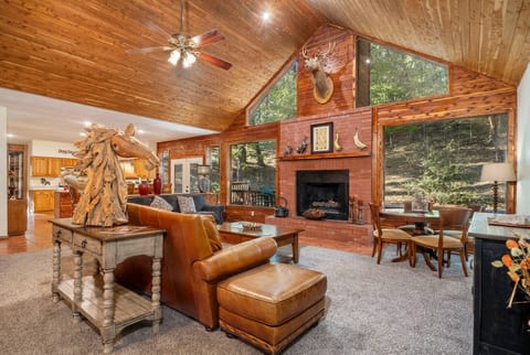 Spacious family room with vaulted ceilings, views of the woods and wildlife, gas fireplace, and plenty of room for everyone. There is a smart tv, a card/ puzzle table, leather sofas and loads of ambiance.