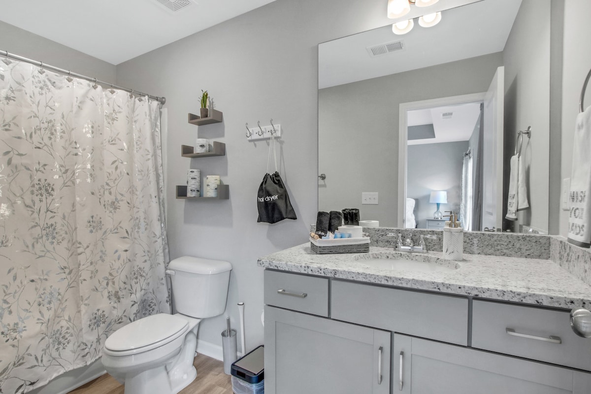 Master bathroom with hairdryer and bath essentials 