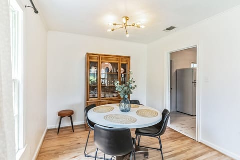 Comfy dining space with lots of fancy drinking glass options.  The pink china set was the inspiration for the front door color and was found here during the clean out phase of renovations!  Pull up the table height padded stools for seating for 6. 