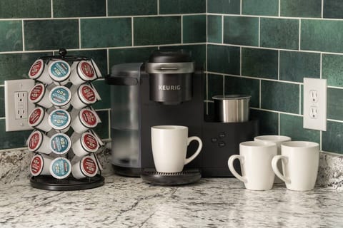 Get your caffeine fix easily with a fully stocked coffee corner featuring a Keurig machine, mugs, and a wide selection of pods.