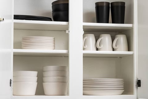Fully stocked cabinets keep things simple — dishes, mugs, and drinkware are all within easy reach and ready for use.