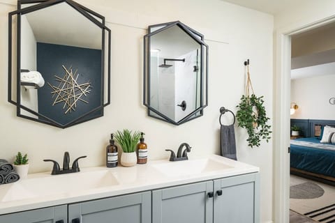 A sleek double vanity setup with bold geometric mirrors and matte black fixtures — clean, modern, and easy to share.