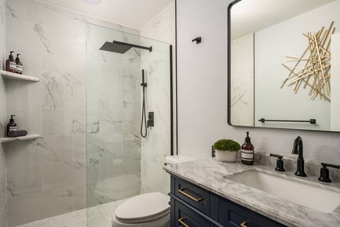 A clean, modern bathroom with a walk-in shower and spacious counter — stocked with essentials to help you settle in.