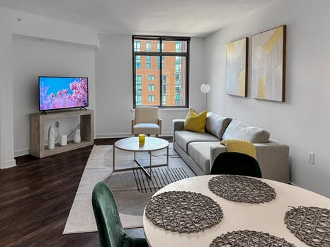 Modern & Bright Living Area. Cozy sectional, smart TV and large windows bring in natural light. Includes a dining space perfect for meals or work.