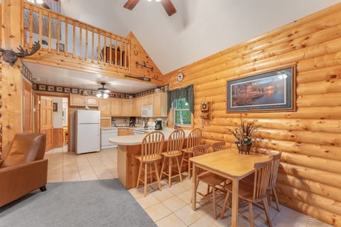 Cozy log cabin interior with loft, full kitchen, and charming dining area
