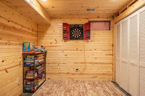 Cozy wood-paneled game nook with dartboard and board games