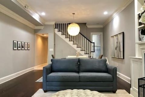 Open-concept living with a queen sofa bed, tufted ottoman, and elegant dining space—perfect for relaxing, entertaining, or unwinding in style.