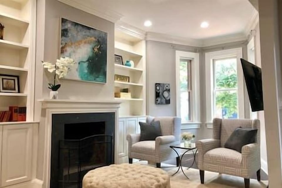 Step inside this elegantly styled living room with custom built-ins, cozy accents, and beautiful natural light to welcome you.
