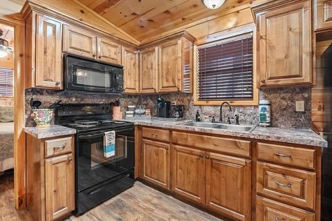 Fully equipped rustic kitchen with warm wood accents, modern appliances, and everything you need to cook your favorite meals during your cozy cabin retreat.