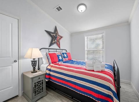 Comfortable bedroom with patriotic décor and soft bedding. A cozy, inviting space designed for restful nights during your cabin getaway.