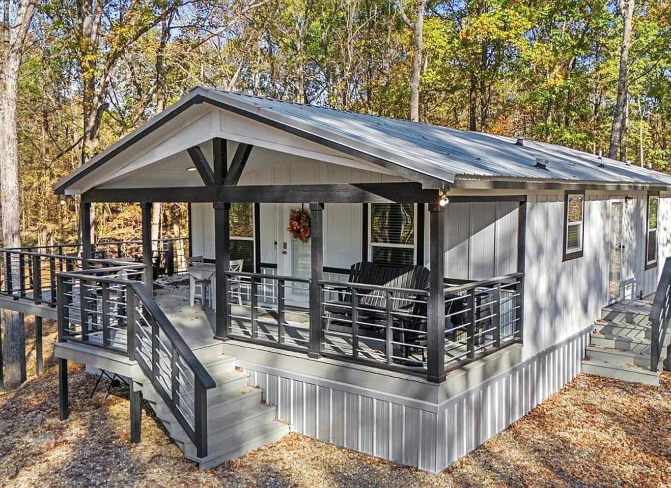 Modern cabin with a stylish covered porch and forest views. Enjoy peaceful mornings, cozy evenings, and a relaxing outdoor space perfect for unwinding.