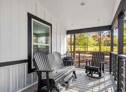 Cozy porch seating with peaceful outdoor views—ideal for morning coffee, afternoon relaxation, or quiet conversations surrounded by nature.